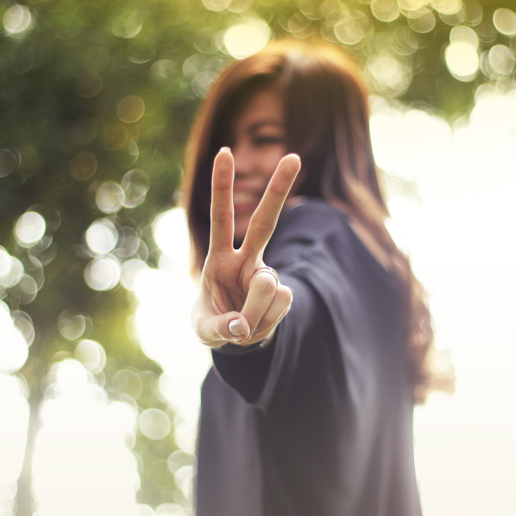 Young Asian female holding up two fingers